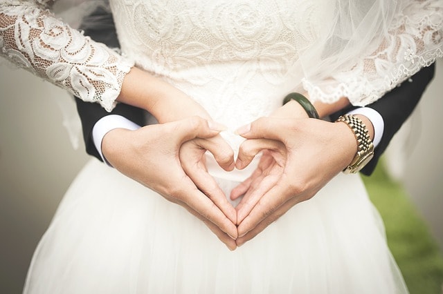 Rear view of husband and wife using hands to form a heart